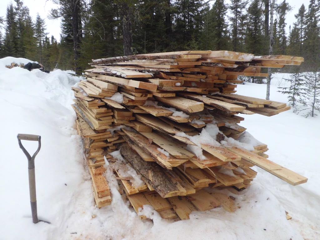 Pile of slab lumber in the snow.