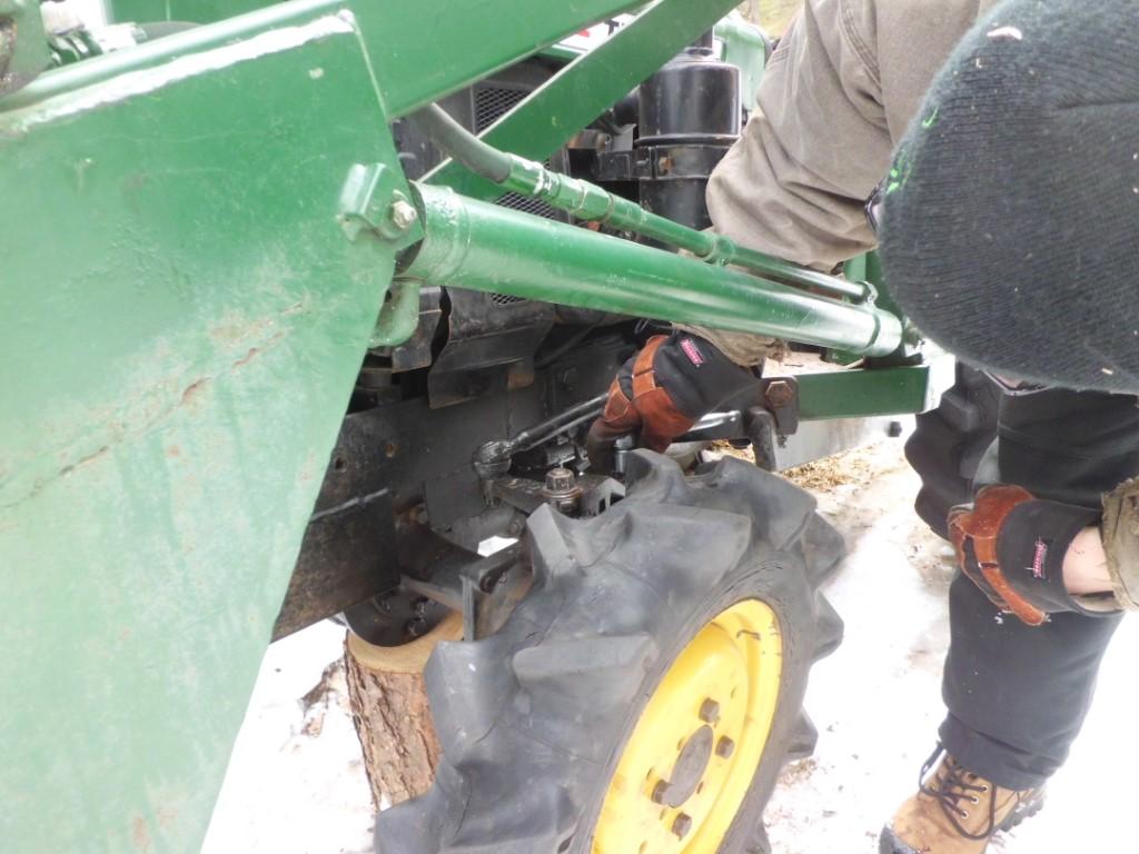 Man adjusting a tractor tire.