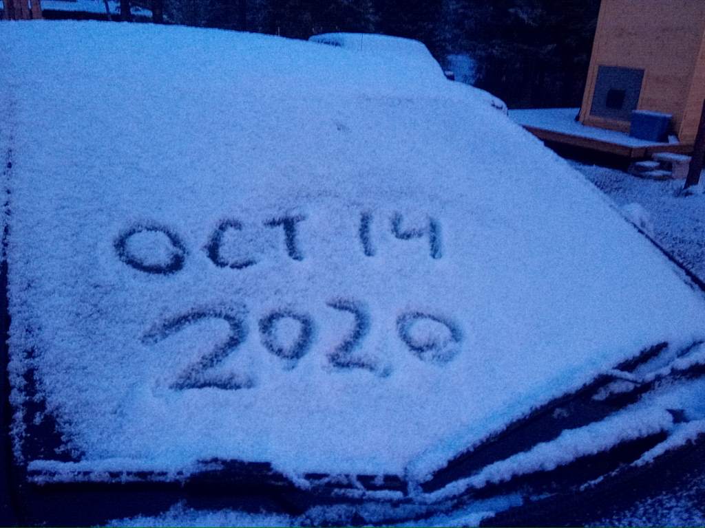 Car windscreen with "Oct 14 2020" drawn in snow.