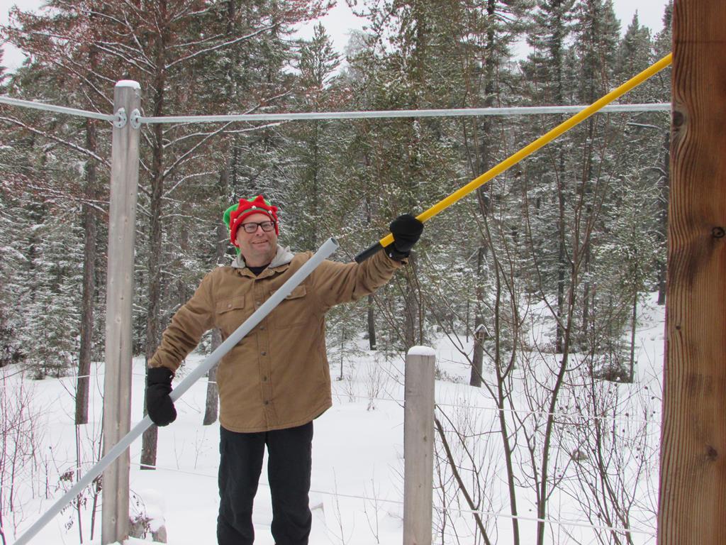 Man connecting an extension to his pole in winter.
