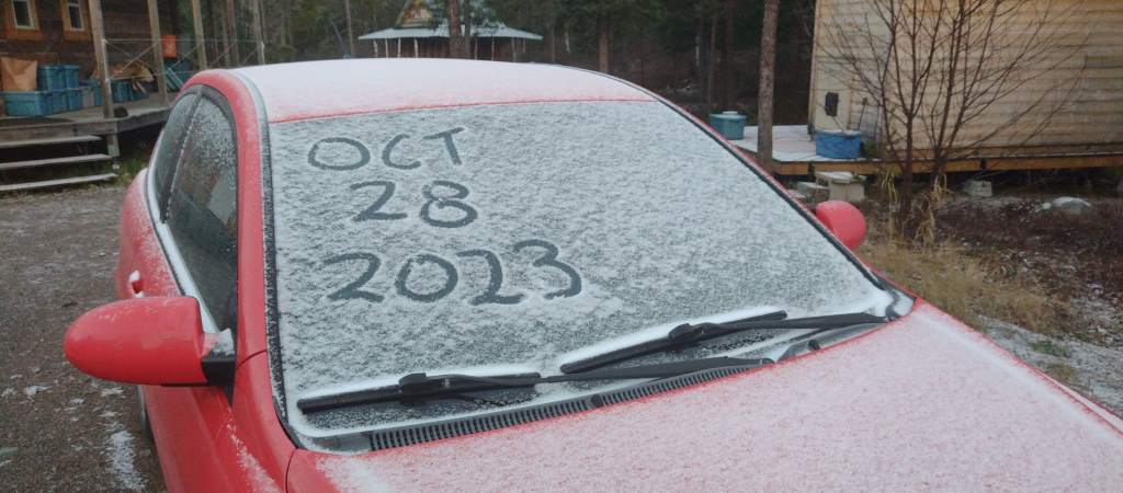 Car windscreen with "Oct 28 2023" drawn in snow.